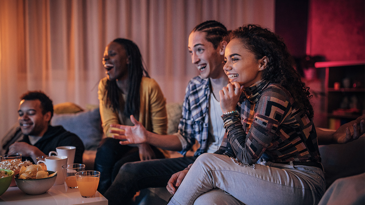 Three women watching TV and having cold drinks